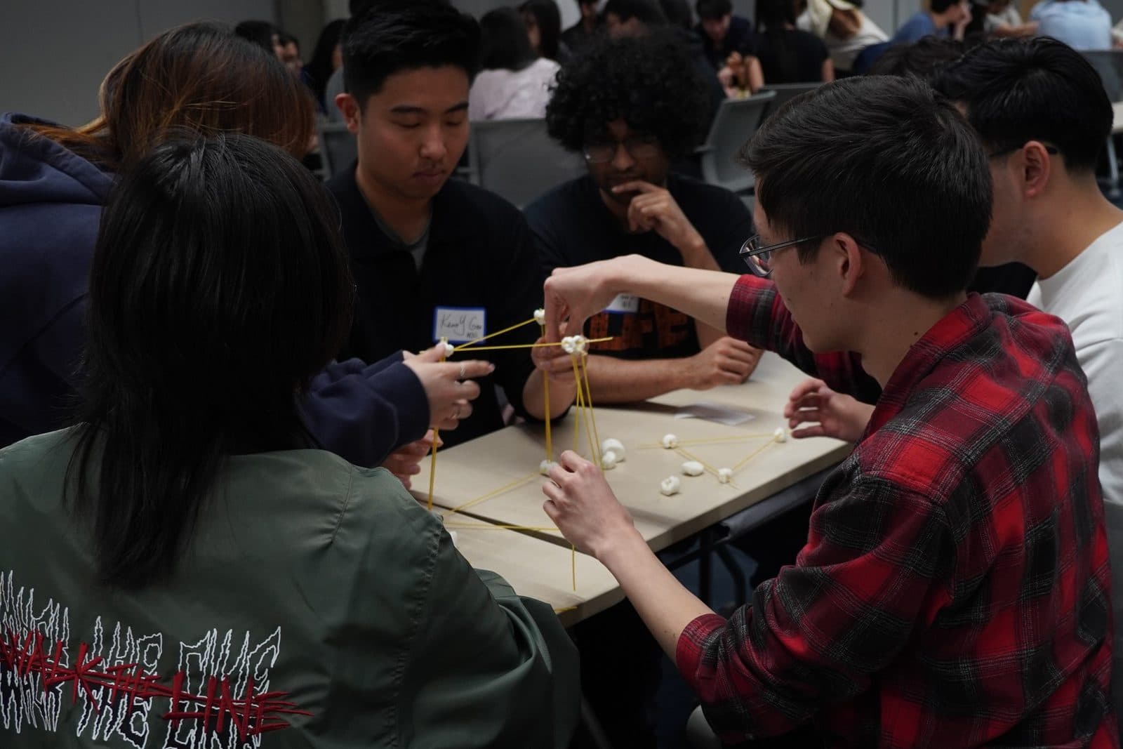 A team building a spaghetti and marshmallow tower